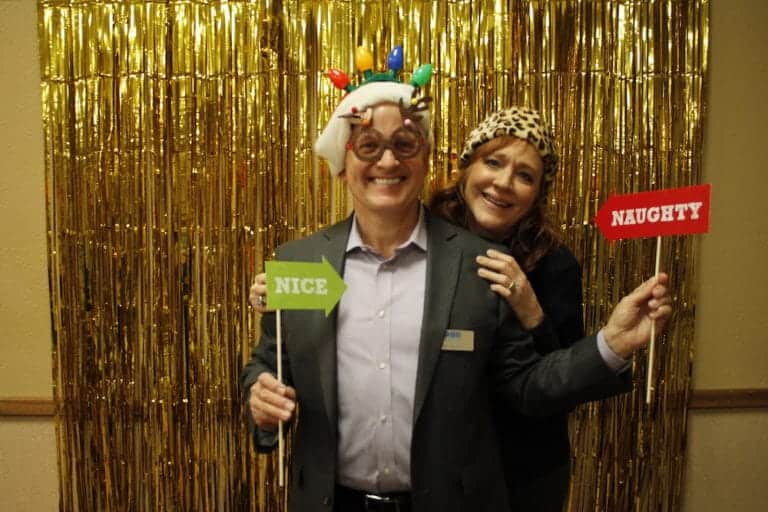 Two people celebrating at 2018 Christmas Party with festive accessories.
