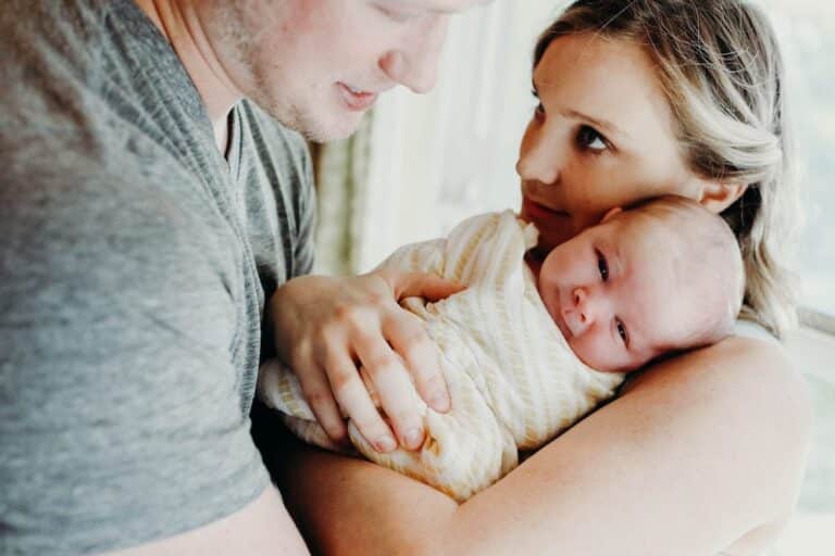 Say Hello To Rhonan 3 Happy family with newborn baby, mother, and father in a cozy home setting.