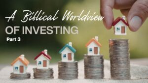 Stacked coins with small house models representing biblical investing principles.