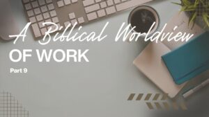Work desk with keyboard, coffee, notebooks, and plant for a biblical worldview of work.